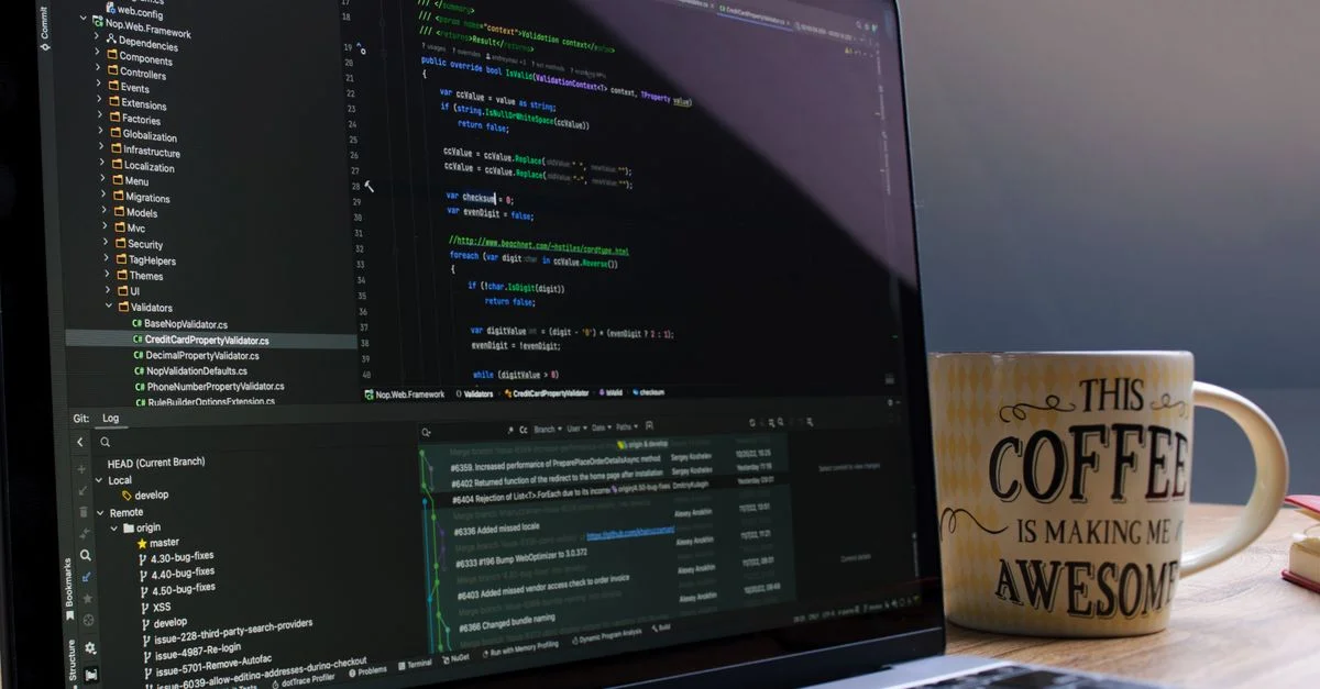Gros plan sur un ordinateur portable avec un logiciel de codage et une tasse de café motivante sur un bureau.